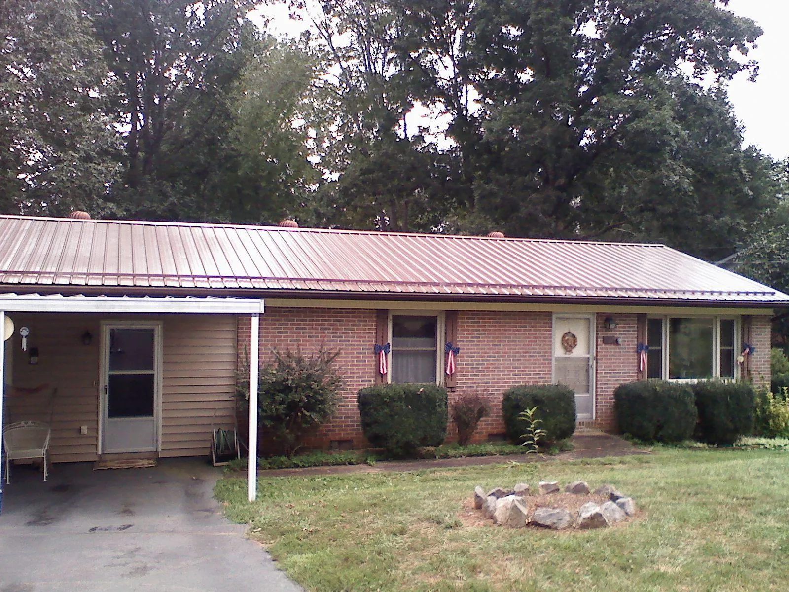 Bronze metal roof and carport on a brick ranch home — Roof Repair work by our crew in Saint Helena Island